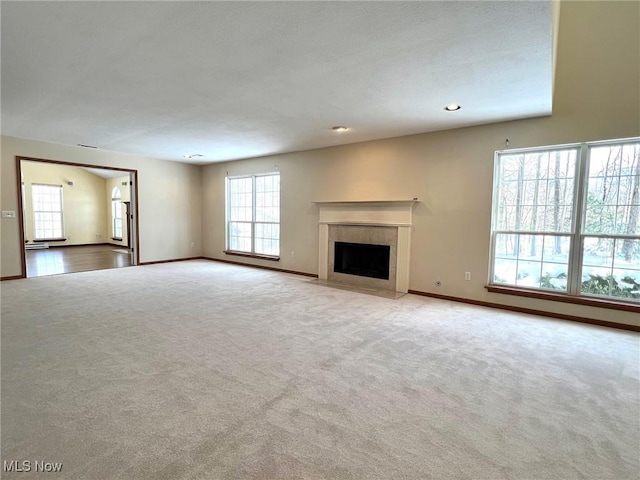 unfurnished living room with light carpet and a healthy amount of sunlight