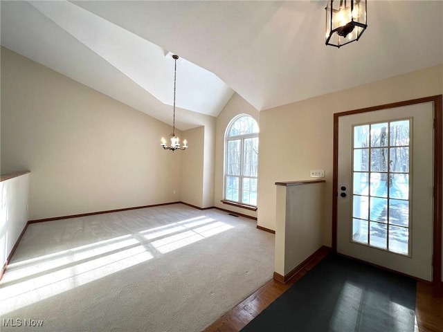 doorway featuring carpet, a chandelier, and vaulted ceiling