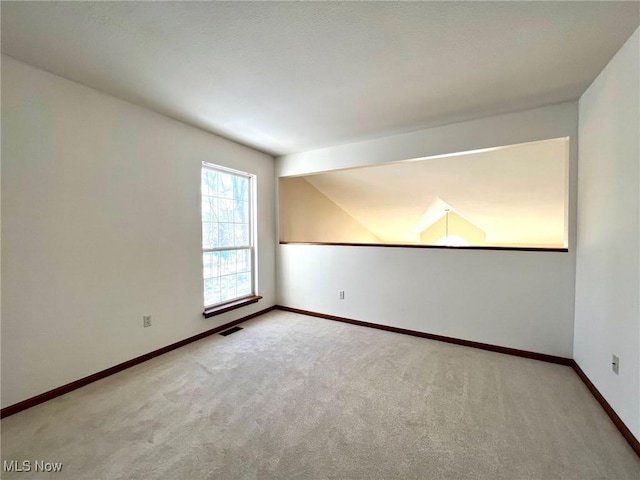 unfurnished room featuring carpet flooring and lofted ceiling