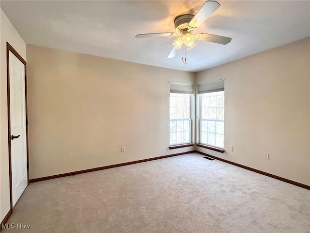 carpeted spare room featuring ceiling fan