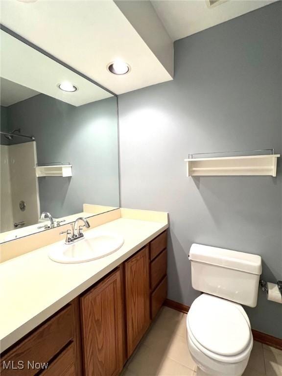 bathroom with tile patterned floors, vanity, toilet, and walk in shower