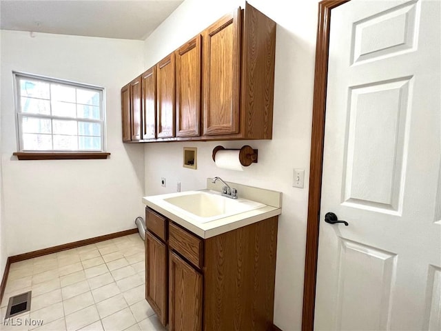 laundry area featuring electric dryer hookup, cabinets, sink, hookup for a washing machine, and light tile patterned floors