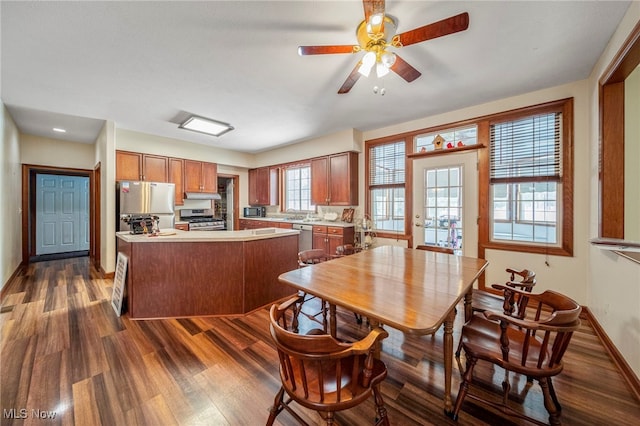 kitchen with dark wood-type flooring, ceiling fan, and appliances with stainless steel finishes