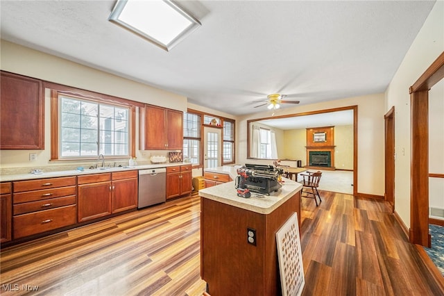 11579 Olde Stone Ct, Concord, OH 44077 - kitchen with stainless steel dishwasher, a sink, light countertops, light wood-style floors, and a kitchen island