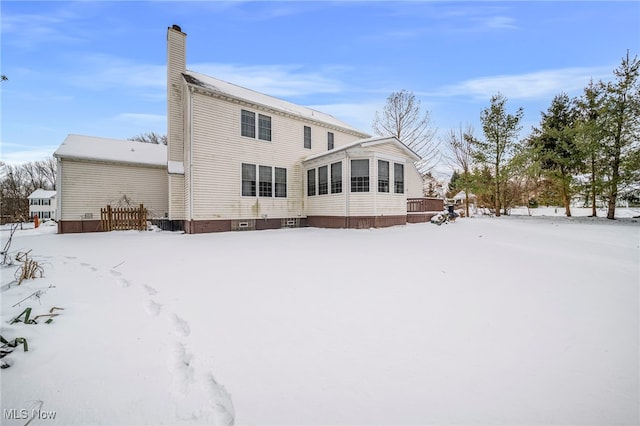 view of snow covered back of property