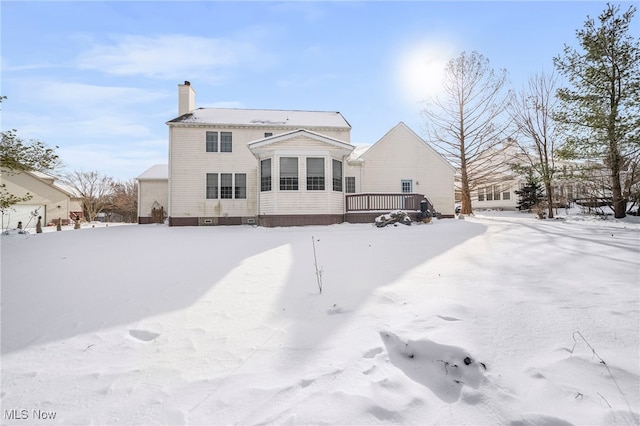 snow covered rear of property featuring a wooden deck