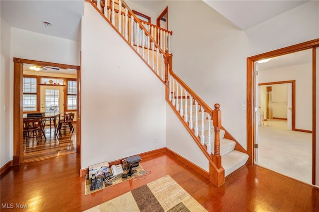 stairway featuring a high ceiling and hardwood / wood-style floors