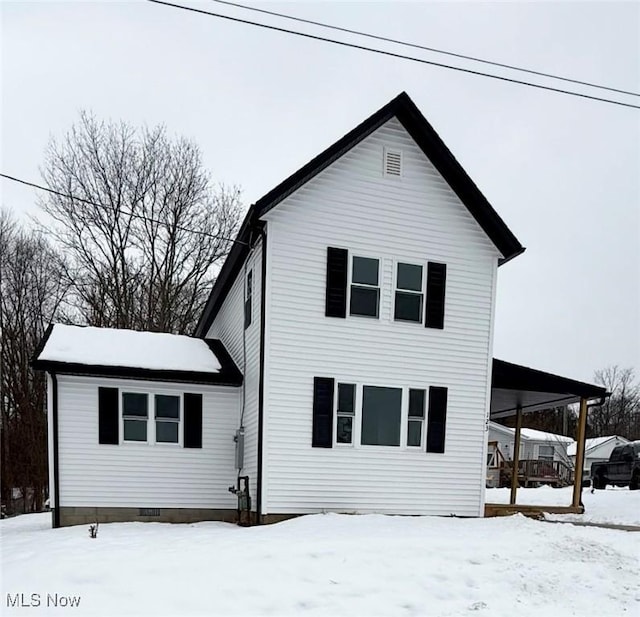 view of snow covered rear of property