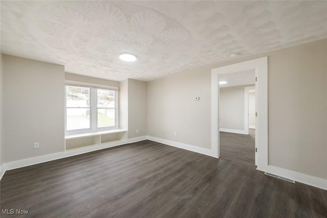 empty room with dark hardwood / wood-style floors