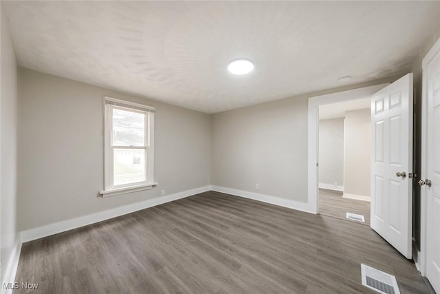 unfurnished room with dark hardwood / wood-style flooring