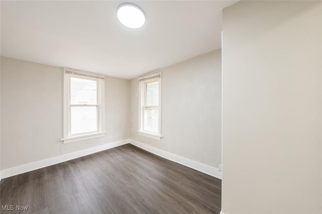 unfurnished room with a healthy amount of sunlight and dark hardwood / wood-style flooring