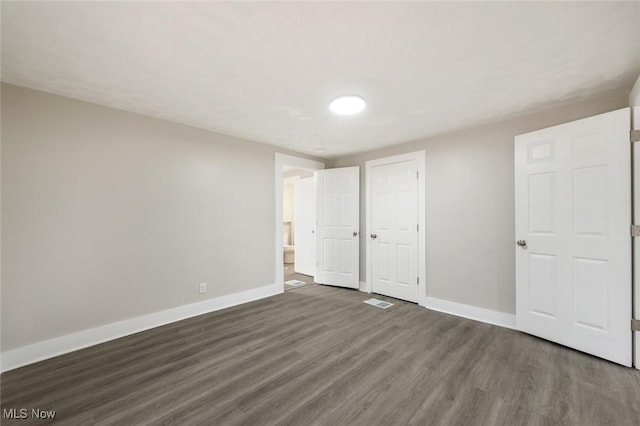 unfurnished bedroom with dark hardwood / wood-style flooring