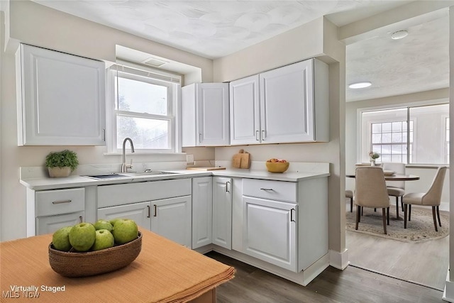 kitchen featuring dark hardwood / wood-style flooring, white cabinetry, and sink