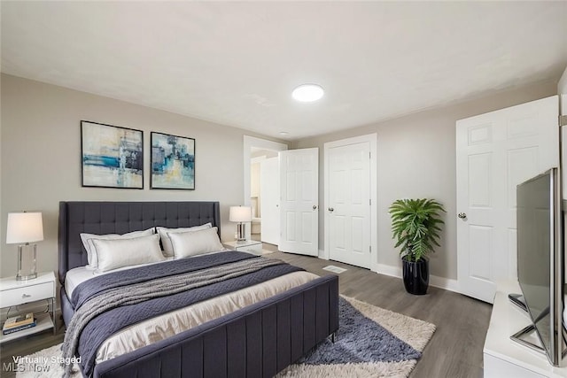 bedroom with dark hardwood / wood-style flooring