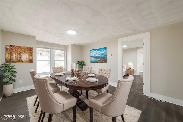 dining area featuring dark wood-type flooring and a textured ceiling