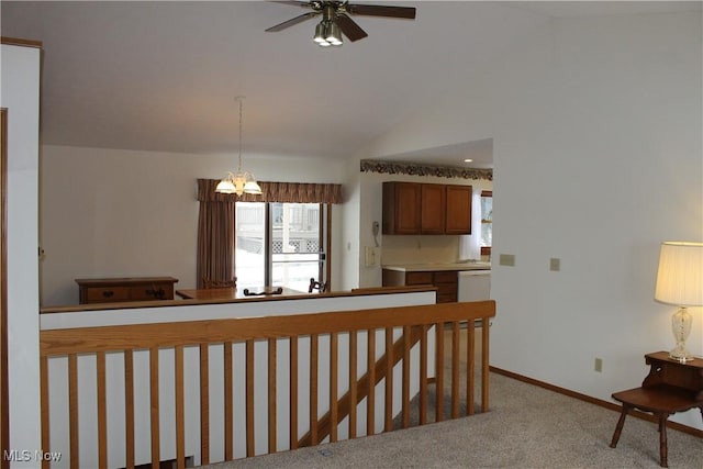 hall with lofted ceiling, light colored carpet, and a notable chandelier