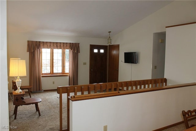 carpeted foyer with lofted ceiling