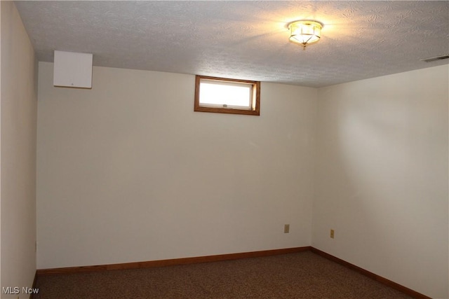 basement featuring carpet flooring and a textured ceiling