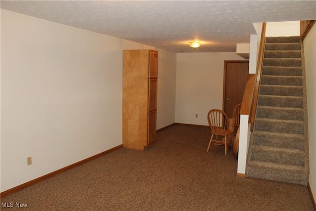 interior space with dark colored carpet and a textured ceiling