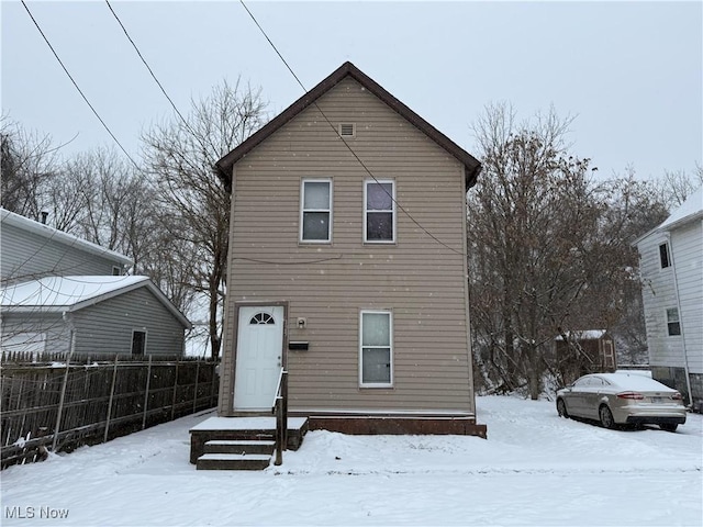 view of snow covered back of property