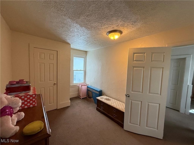 bedroom featuring a textured ceiling and carpet floors