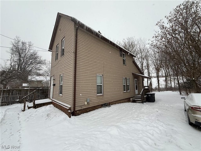 view of snow covered back of property