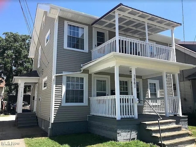 rear view of house featuring a porch and a balcony