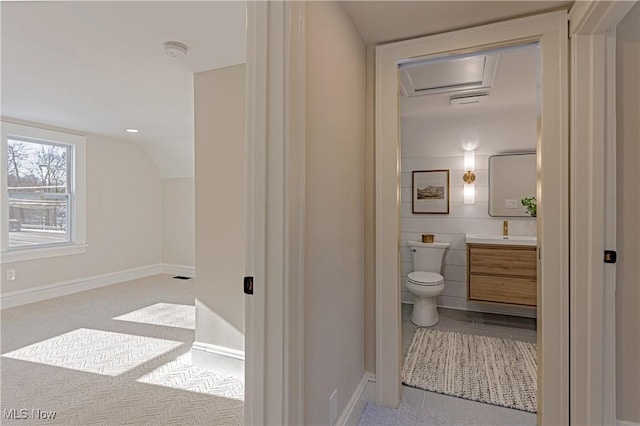 bathroom featuring vanity, lofted ceiling, and toilet