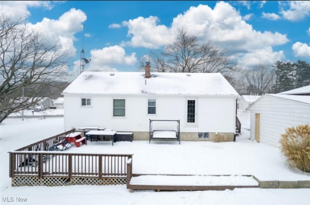 snow covered rear of property featuring a wooden deck