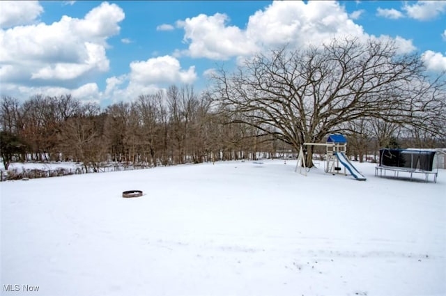 snowy yard featuring a playground