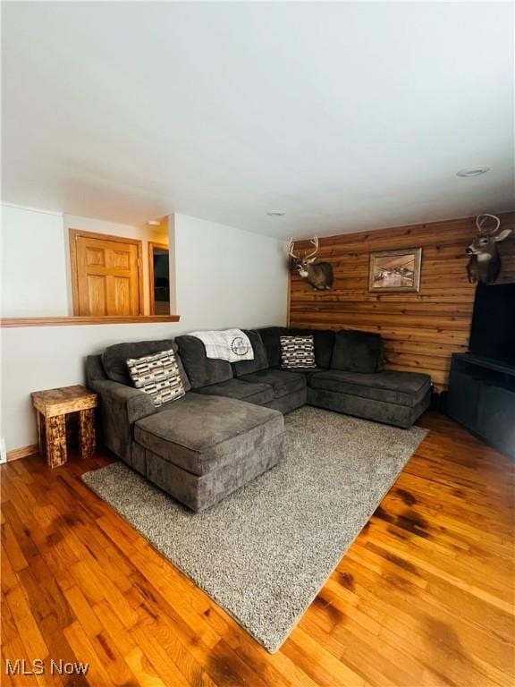 living room featuring wooden walls and hardwood / wood-style floors