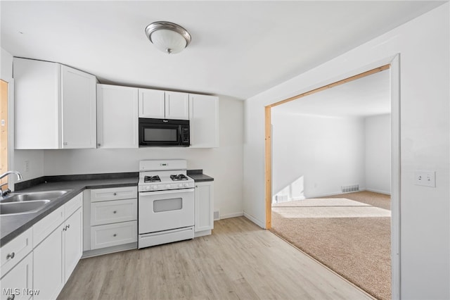 kitchen featuring white cabinetry, white gas range, sink, and light hardwood / wood-style flooring