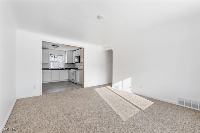 unfurnished living room featuring light carpet