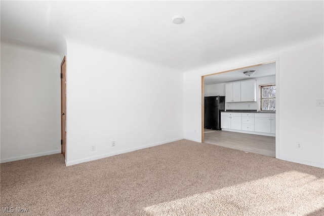 unfurnished living room featuring light colored carpet