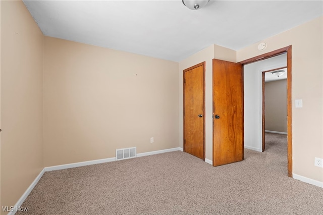 unfurnished bedroom featuring a closet and light colored carpet