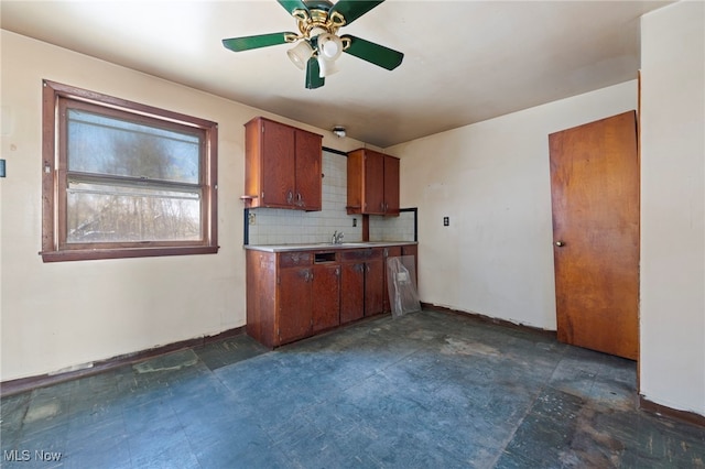 kitchen featuring backsplash, ceiling fan, and sink