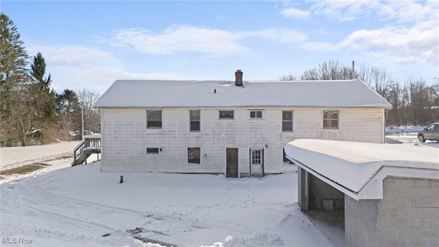 view of snow covered rear of property