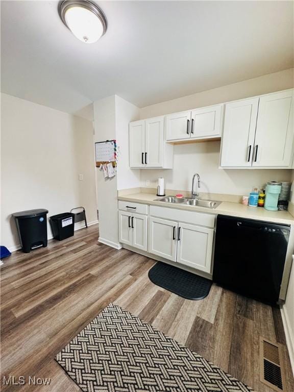 kitchen featuring sink, white cabinets, hardwood / wood-style floors, and black dishwasher