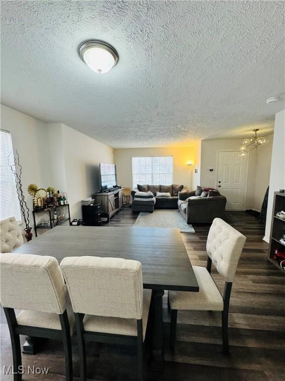 dining space with a textured ceiling and dark wood-type flooring