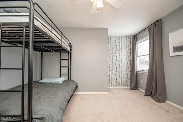 carpeted bedroom featuring baseboards and ceiling fan