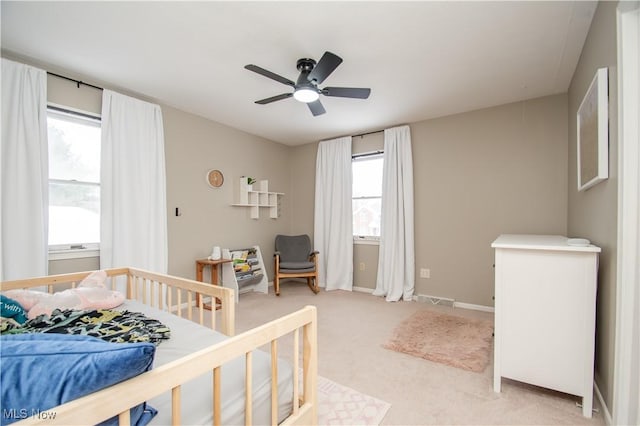 bedroom with visible vents, light carpet, baseboards, and a ceiling fan