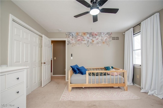 bedroom featuring visible vents, baseboards, light colored carpet, and ceiling fan