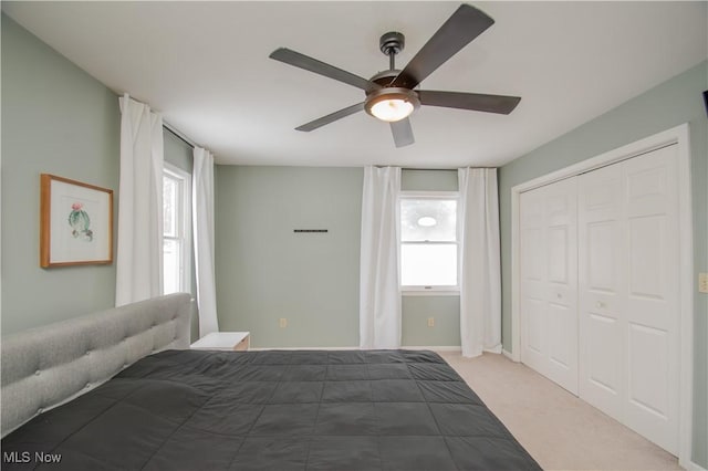 unfurnished bedroom featuring a closet, light colored carpet, and ceiling fan