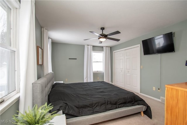 carpeted bedroom featuring baseboards, a closet, and ceiling fan