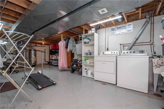 below grade area with washer and dryer, concrete block wall, and water heater