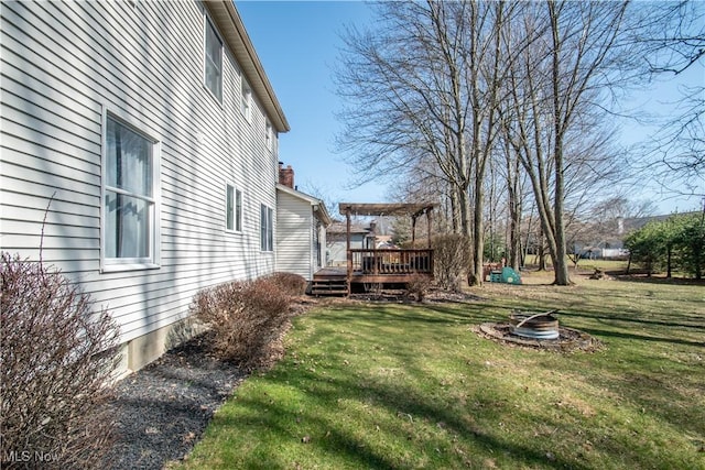 view of yard featuring a wooden deck and a fire pit