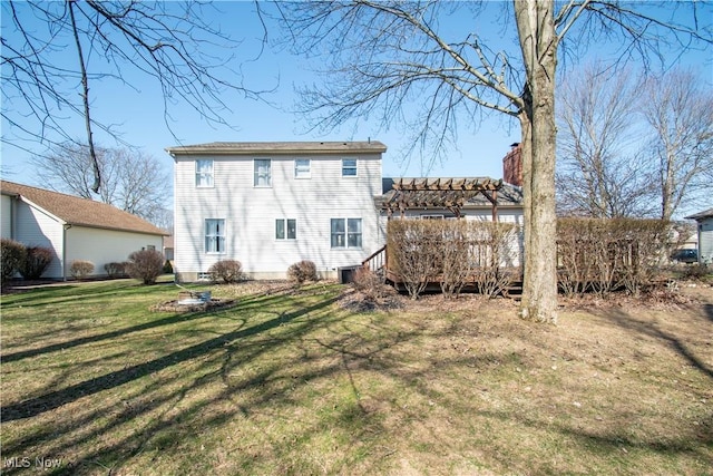 rear view of property featuring a yard, a deck, a chimney, and a pergola