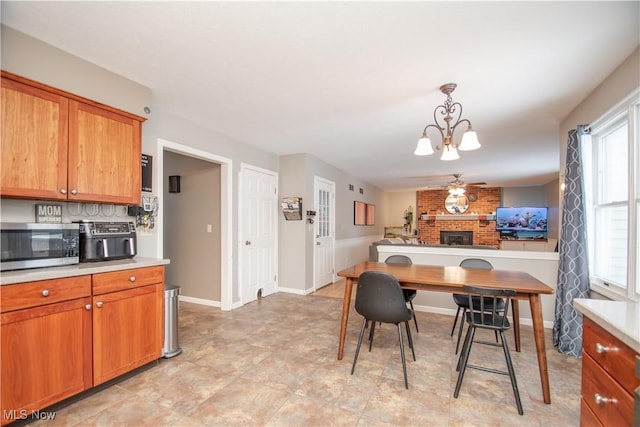 dining room with a notable chandelier, a fireplace, and baseboards