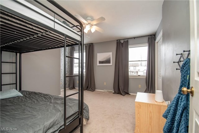 bedroom featuring light colored carpet, baseboards, and ceiling fan