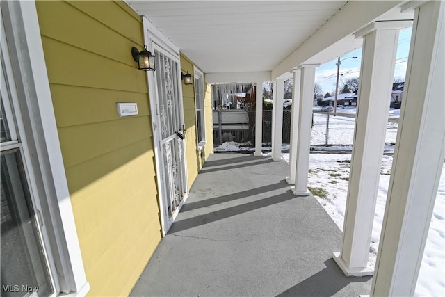 snow covered patio featuring covered porch